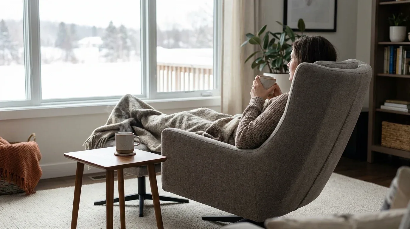 Person relaxing in a gently rocking recliner during a quiet winter afternoon.
