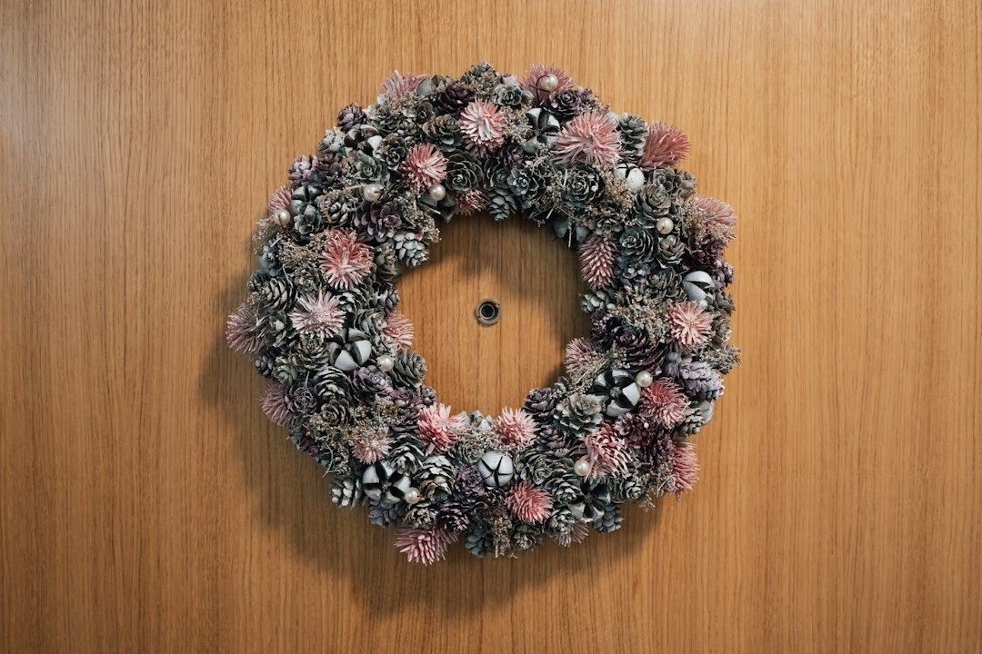 Pinecone and dried flower wreath on a wooden front door