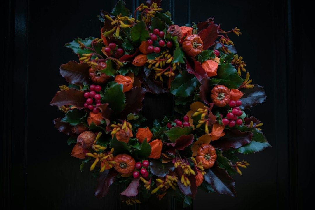 Autumn wreath with red berries, physalis and dark red leaves on a front door
